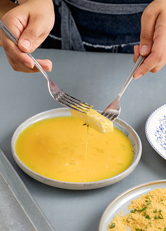 Pase por el <strong>batido de huevo</strong> los bastones de queso.