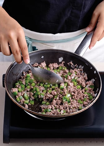 Acitrona la cebolla, los pimientos y añade la carne. Salpimienta y cocina hasta que la carne esté cocida. Deja enfriar.