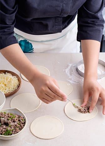 Rellena la mitad de los círculos con la carne y el resto con los granos de elote y el queso.