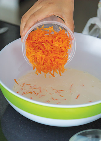 AGREGA el 1 1/2 taza de zanahoria rallada, la lata de piña en almíbar en cubos y las nueces picadas.