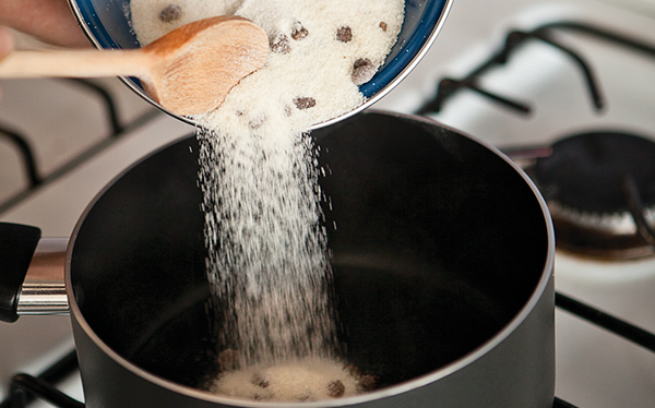 Calienta el agua a fuego alto y agrega el azúcar, el piloncillo y la miel de maíz; mueve con una cuchara para que se disuelva todo y cocina hasta que se forme un caramelo.
