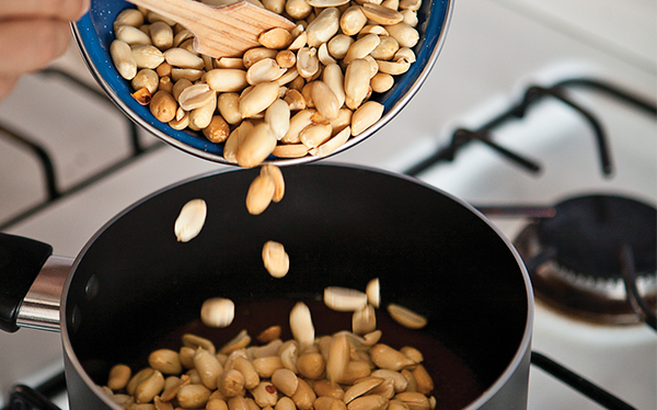 Añade los cacahuates y la mantequilla. Mezcla para que todo el <strong></img>cacahuate</strong> se bañe con el caramelo y retira del fuego de inmediato.