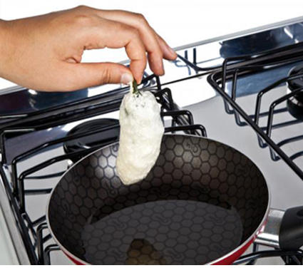Sumerge los chiles uno por uno en el huevo y distribuye sobre el sartén, con el aceite caliente.
