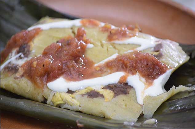 Tamales de frijol con pollo y queso oaxaca en hoja de plátano