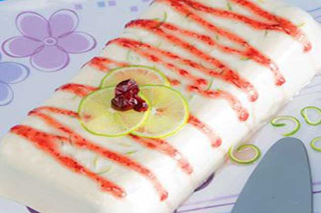 Flan de limón con salsa en zig zag de arándanos y rodajas finas de limón encima