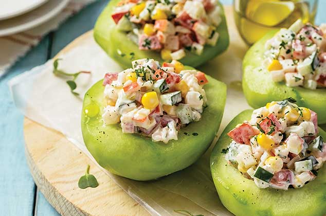 chayores rellenos de ensalada de surimi en un plato de madera