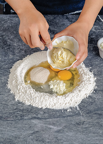 MEZCLA la levadura con 1 cucharada de harina y 1 de azúcar y vierte un poco de agua tibia hasta obtener una masa espesa. Tapa y deja reposar en un lugar caliente. Forma un volcán con la <strong>harina</strong> y haz un hueco en el centro. Añade la sal, la leche en polvo, el resto de la azúcar, el huevo y la mantequilla 