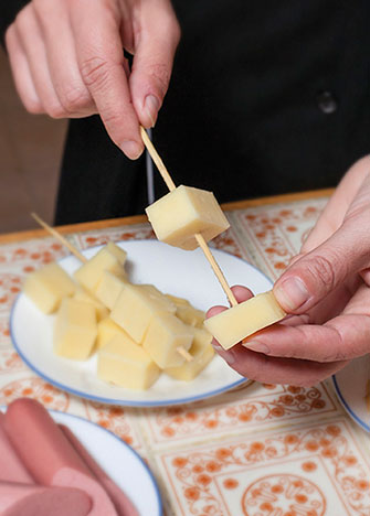 Ensarta el queso, las salchichas y el plátano en los palillos, para formar banderillas con cada ingrediente.
