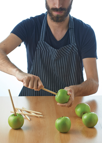 Lava y desinfecta las manzanas, clava firmemente los palitos de madera hasta llegar al centro.

*Baña con jugo de limón el extremo del palito que clavarás en la
manazana; así evitarás que se oxide.