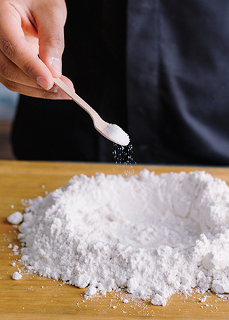 Tamiza la harina y forma un volcán. Añade la sal y el azúcar.
