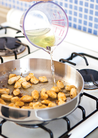 Sofríe el ajo y los echalotes en una cacerola con aceite caliente, añade el pollo y el vino. Cocina por 4 minutos, a fuego medio.