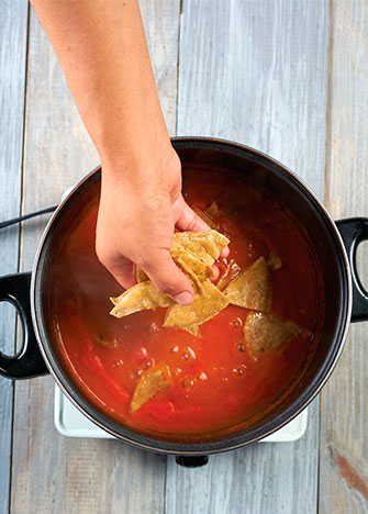 COLOCA los totopos sobre la salsa, mezcla y cocina por unos minutos.