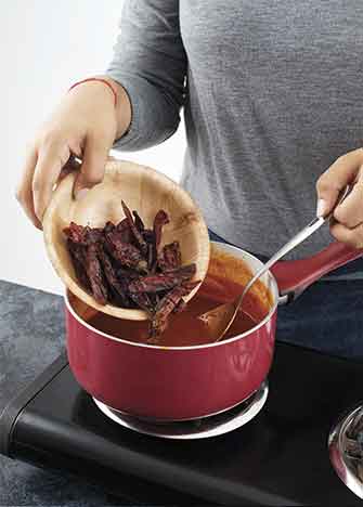 Añade los chiles chipotles, mezcla y cocina por 40 minutos o hasta que espese y los chiles estén suaves.