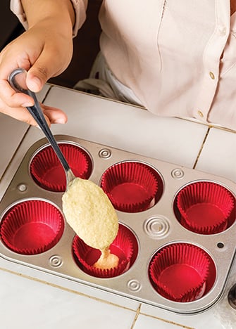 AGREGA las ralladuras y mezcla. Vierte la preparación en moldes para cupcakes con capacillos.