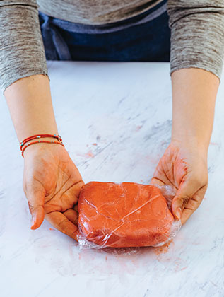 PINTA una mitad con colorante rojo y cubre con plástico cada mitad. Refrigera por 30 minutos.