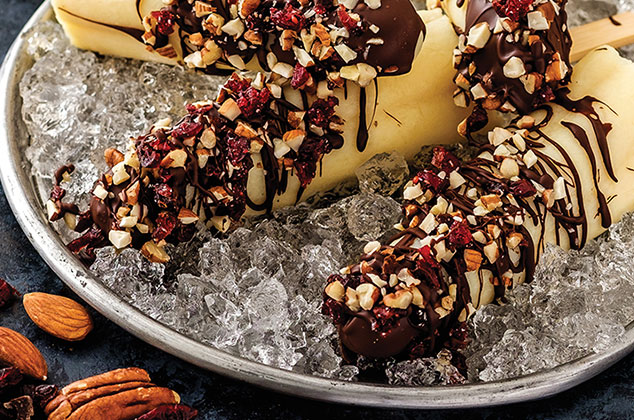 Paletas heladas de rompope cubiertas de chocolate y frutos rojos