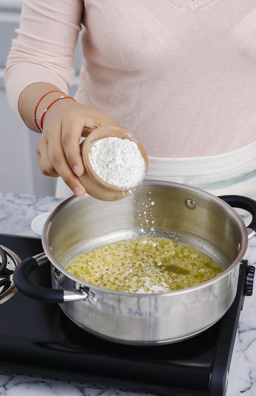 FUNDE la mantequilla y sofríe la cebolla y el ajo.