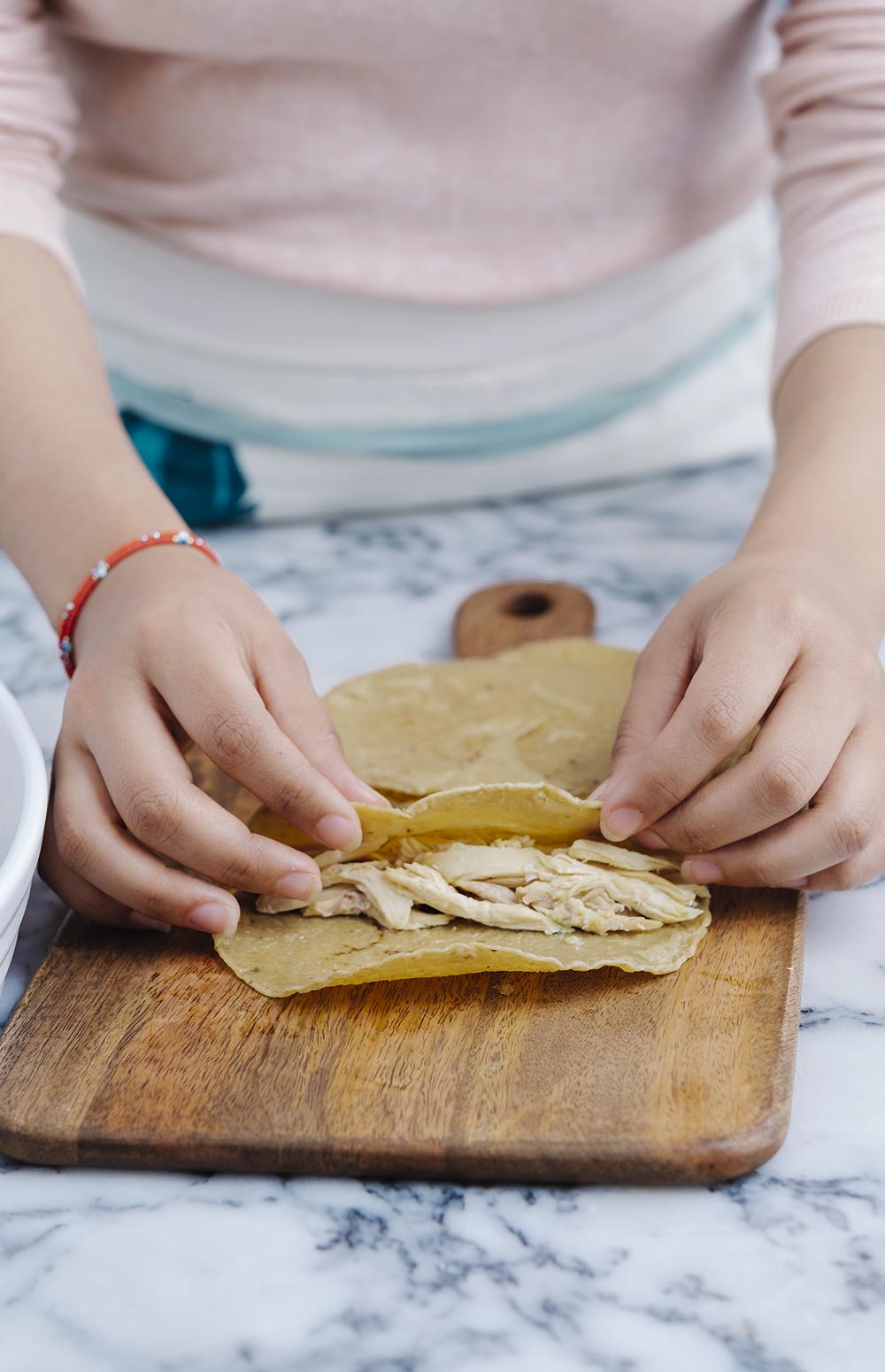 RELLENA las tortillas con pollo y enrolla.