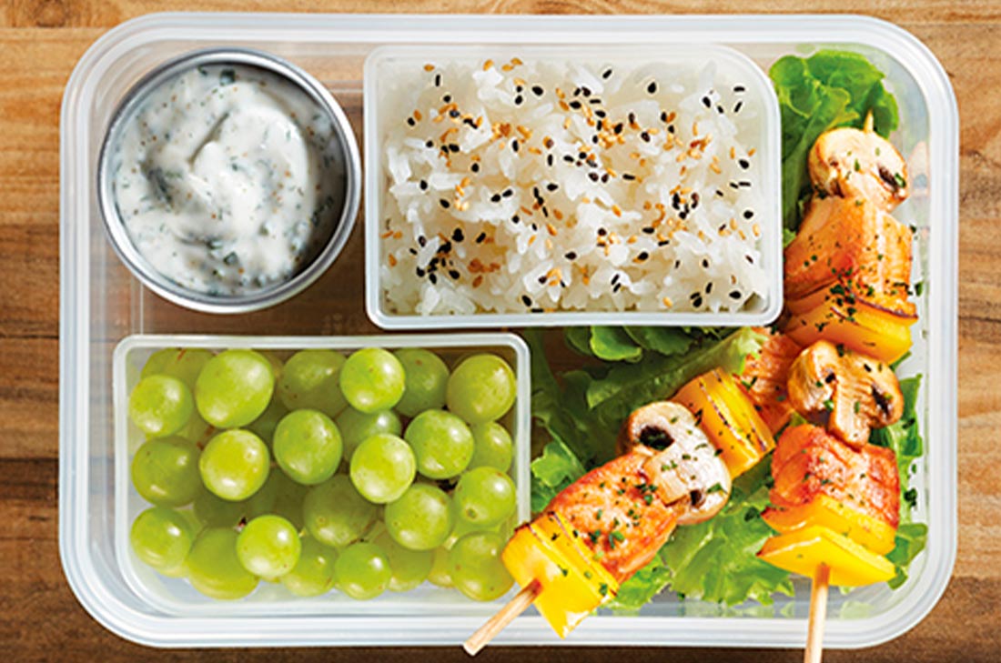 Brochetas de salmón y champiñones, arroz al vapor, uvas y dip de yogur y perejil