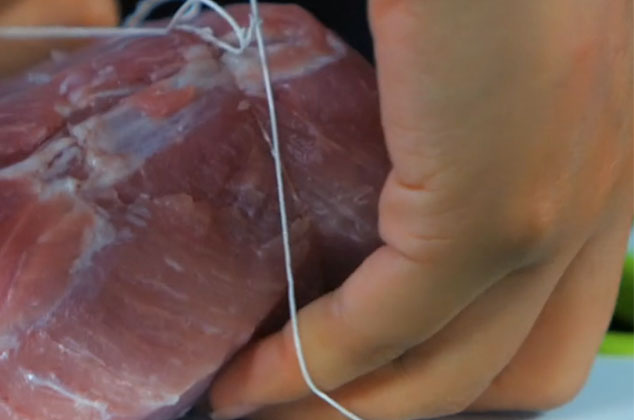 SIN cortar el hilo, haz nudos que rodeen la pieza de carne, tanto a lo ancho como a lo largo.