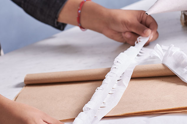 PEGA conos de cartón y decora con papel china formando rizos.