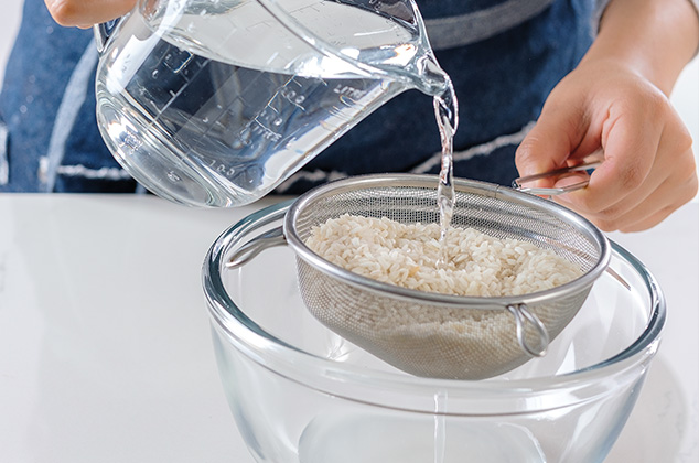 ENJUAGA el arroz bajo el chorro de agua y escurre.
