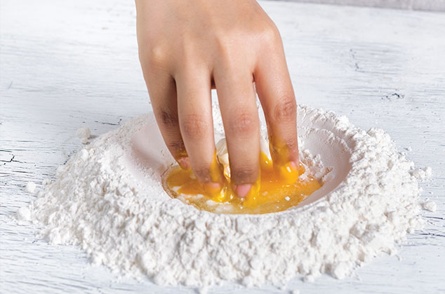 COLOCA la harina sobre una superficie lisa. Forma un hueco al centro. Añade la mantequilla, el huevo, el azúcar, la sal y el polvo para hornear. Mezcla con las yemas de los dedos y ve incorporando la harina poco a poco.