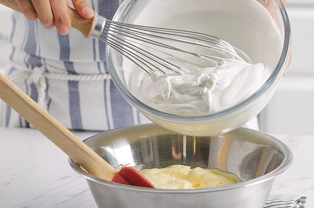AGREGA una tercera parte de la crema batida a la preparación del queso.