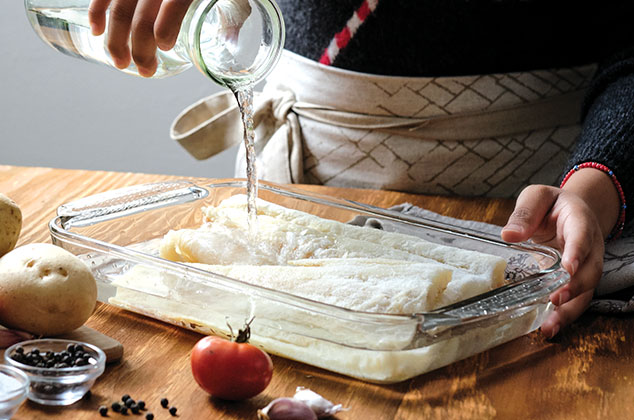 COLOCA el bacalao en un refractario y cubre con agua tibia. Deja reposar por 2 noches antes de la preparación. Cambia el agua cada 6 horas.