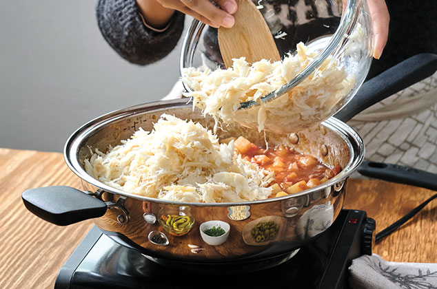 AGREGA el bacalao, las aceitunas y las almendras. Tapa y cocina por 25 minutos. Mueve ocasionalmente.