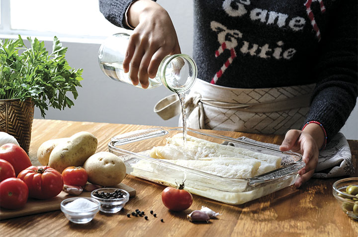 COLOCA el bacalao en un refractario y cubre con agua tibia. Deja reposar por 2 noches antes de la preparación. Cambia el agua cada 6 horas.