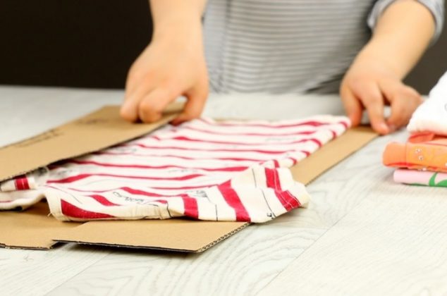 Doblar la ropa. imagen recortada de mujer doblando ropa sobre la mesa