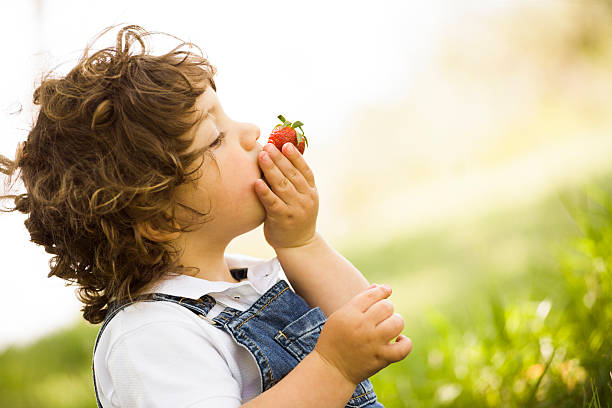 niño comiendo fresas