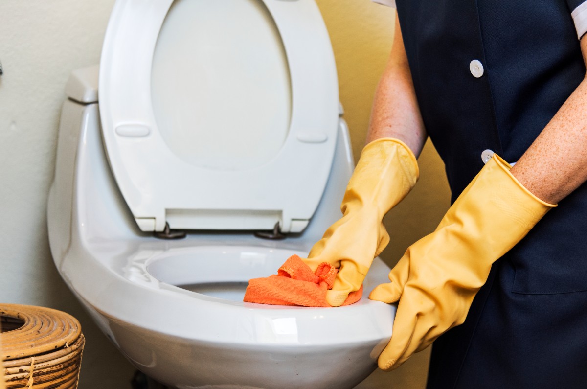 mujer lavando taza del baño