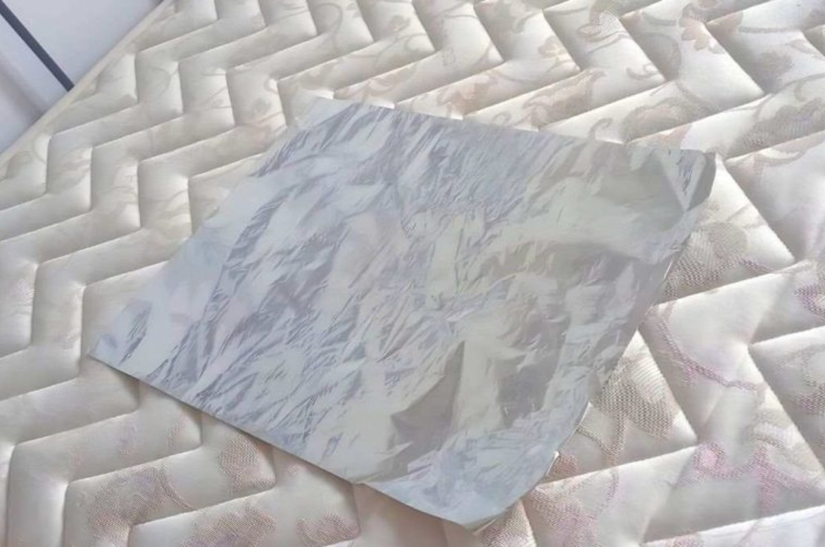 El papel aluminio para evitar accidentes en el colchón, debe colocarse entre la funda del colchón y el propio colchón. 