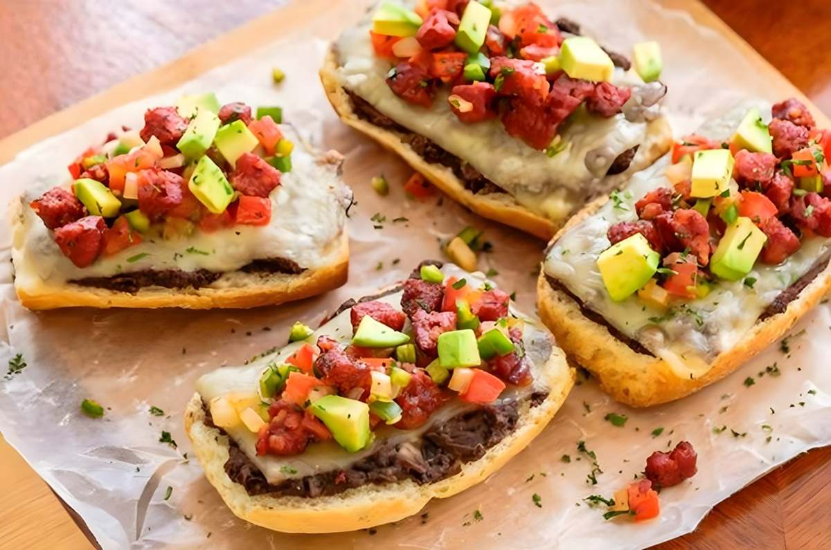 Molletes con frijol, chorizo y queso gratinado